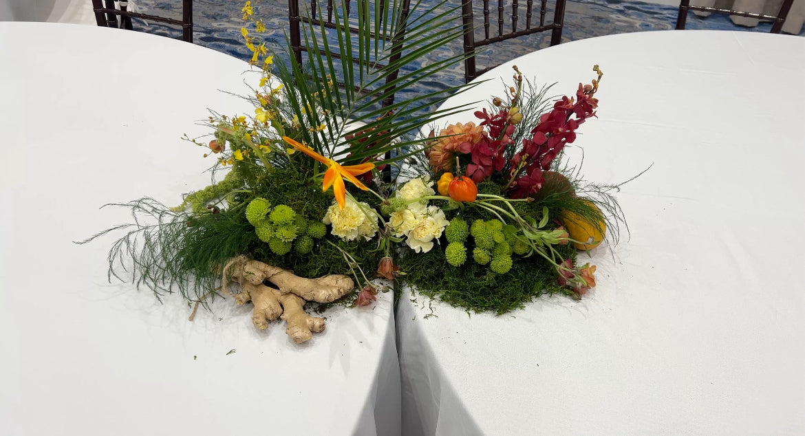 Decorative floral arrangement on a white table with a scenic background